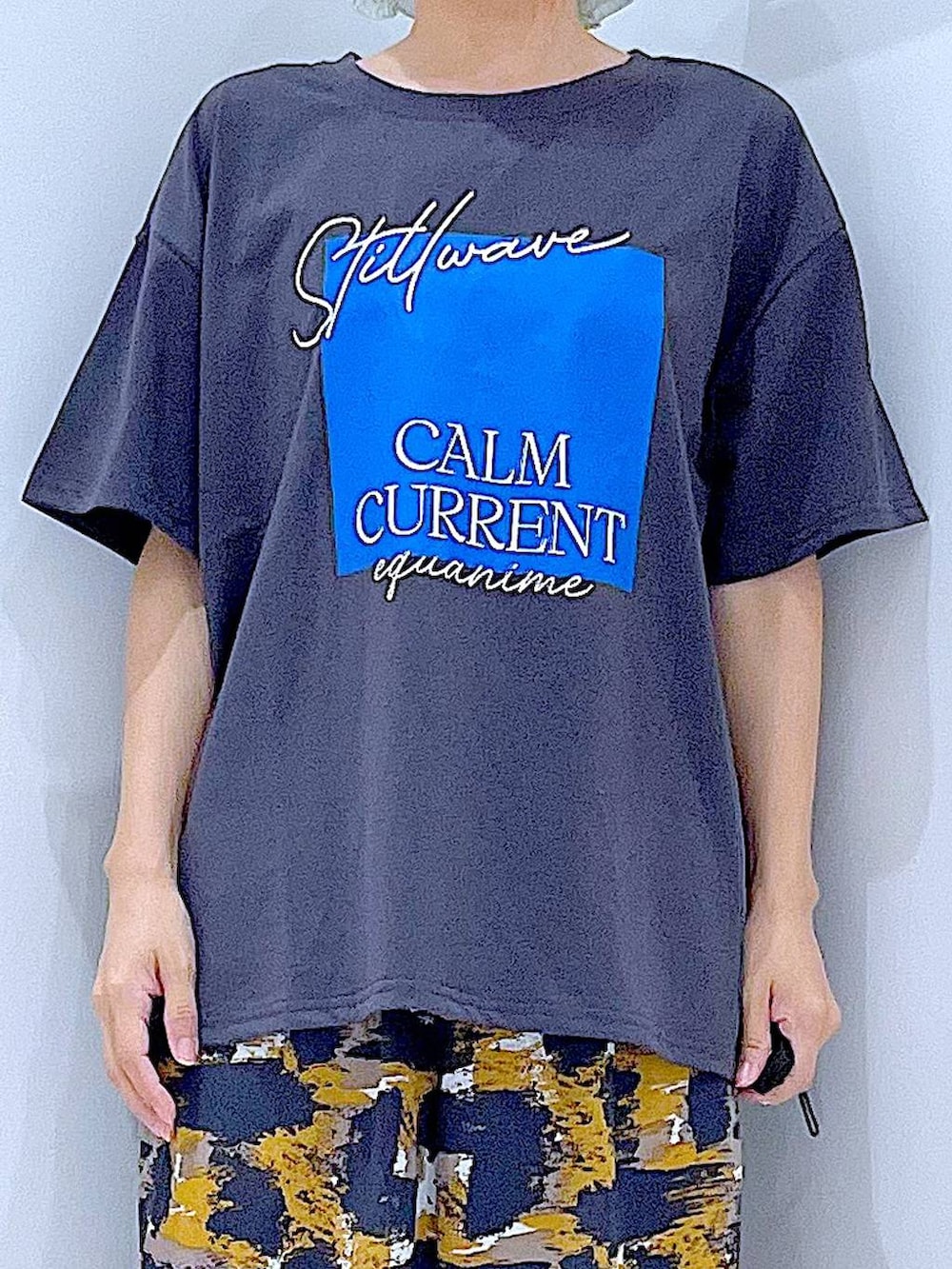 グレー系のTシャツ/カットソー、グレー系のその他パンツ、ブラック系のサンダルを着用したレディースの夏コーディネートの7枚目の写真