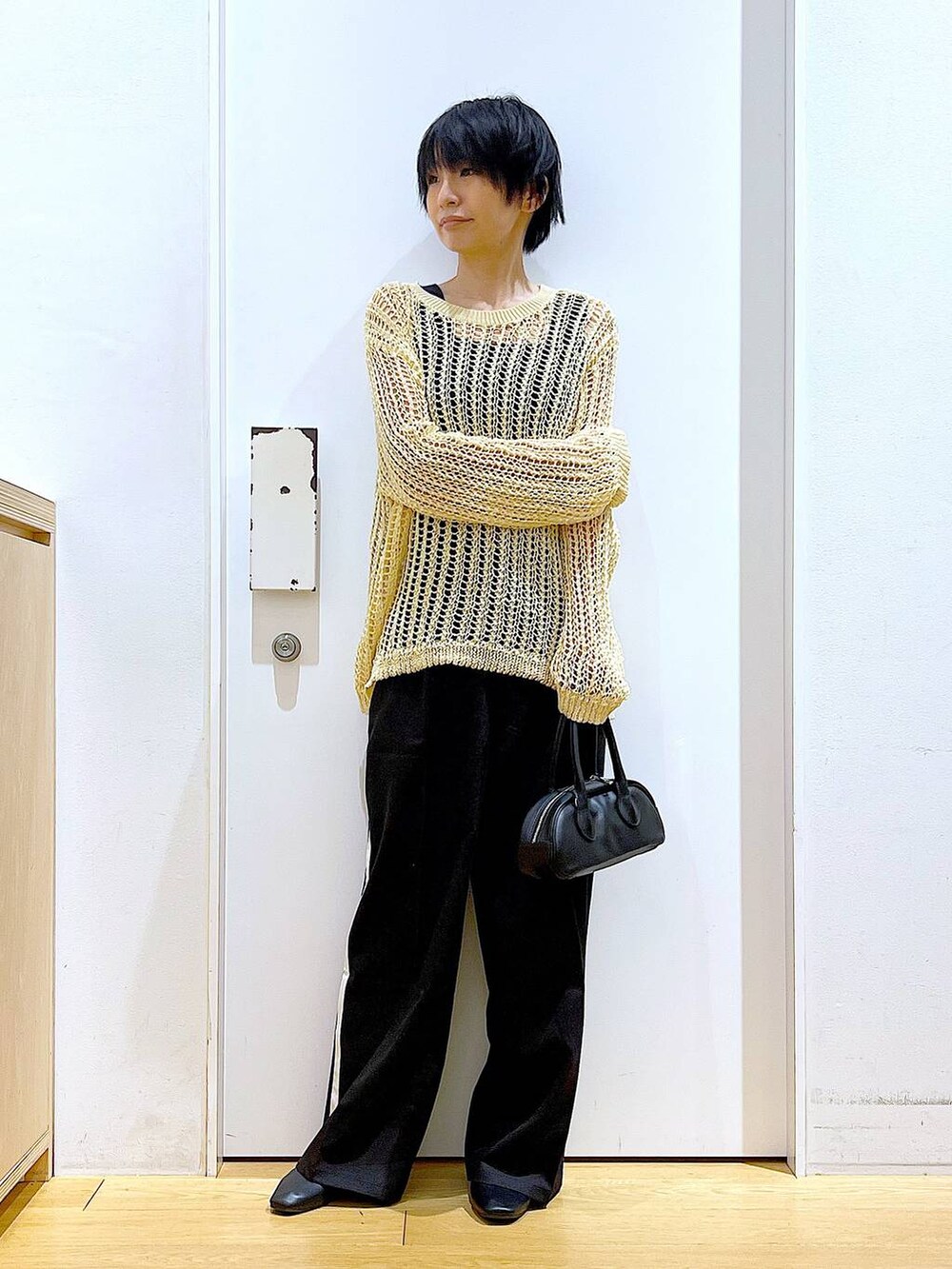 ブラック系のスラックス、ブラック系のボストンバッグ、ブラック系のパンプスを着用したレディースの夏コーディネートの2枚目の写真