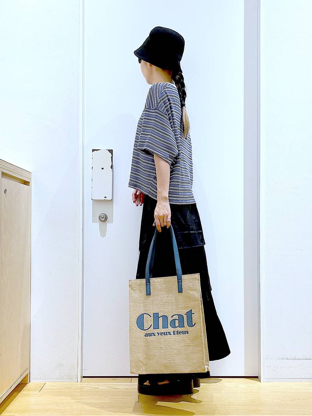 ブラック系のサンダル、グレー系のTシャツ/カットソー、ブルー系のトートバッグを着用したレディースの夏コーディネートの3枚目の写真