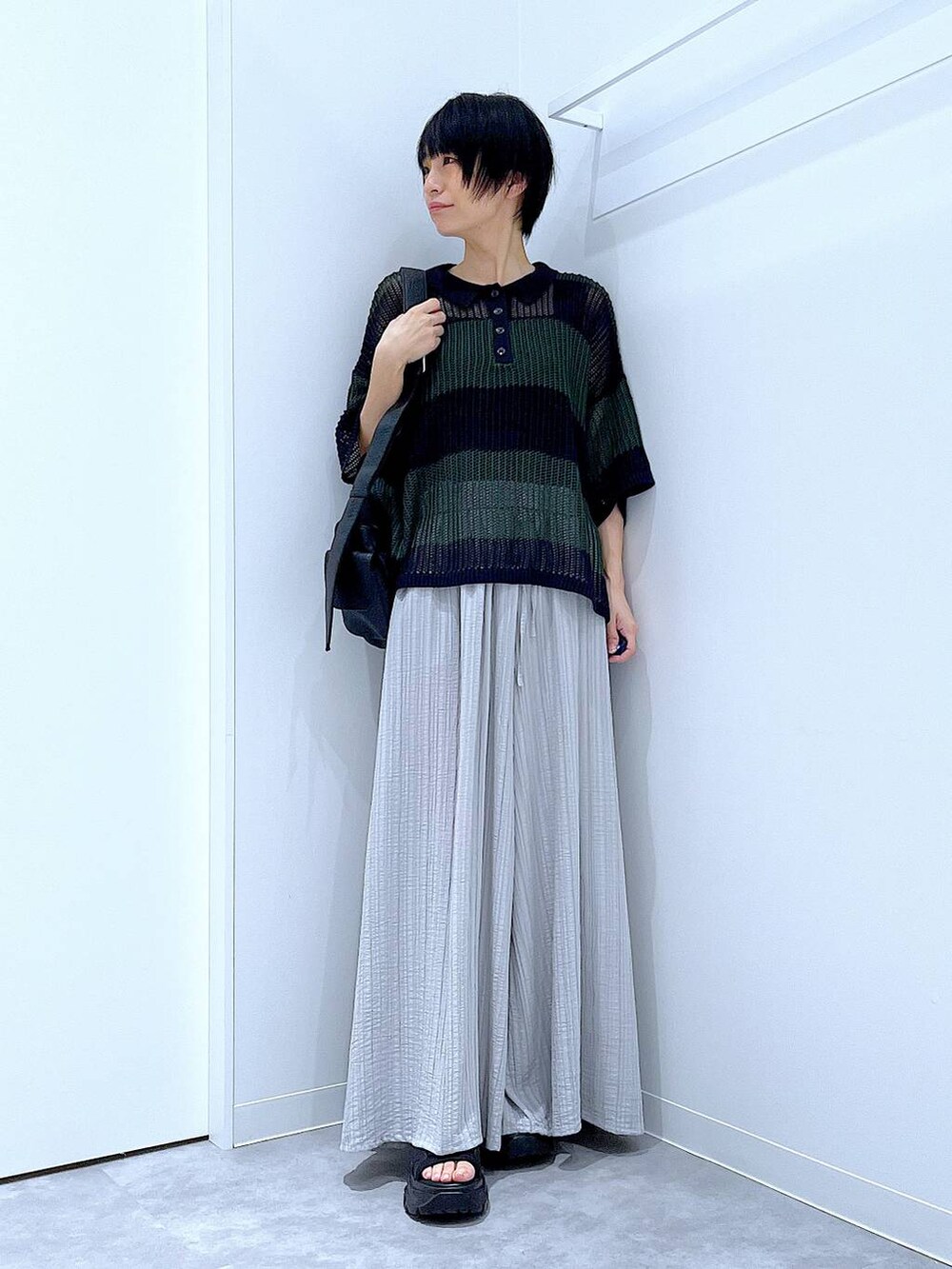 ブラック系のスニーカー、ブラック系のショルダーバッグ、グレー系のその他パンツを着用したレディースの夏コーディネートの2枚目の写真