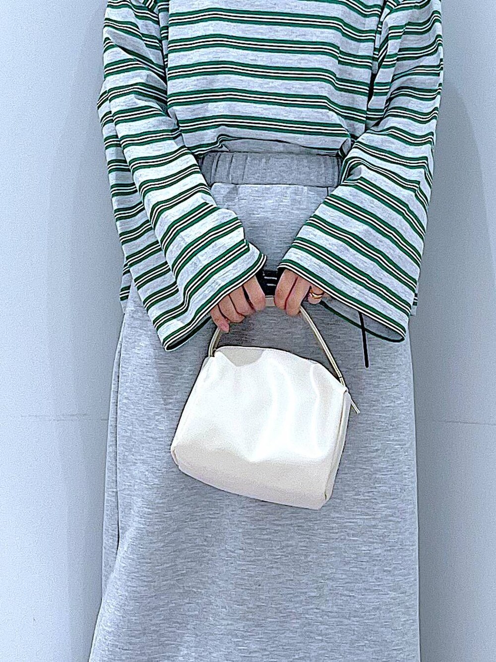 ホワイト系のショルダーバッグ、グレー系のスカート、グレー系のTシャツ/カットソーを着用したレディースの春コーディネートの9枚目の写真