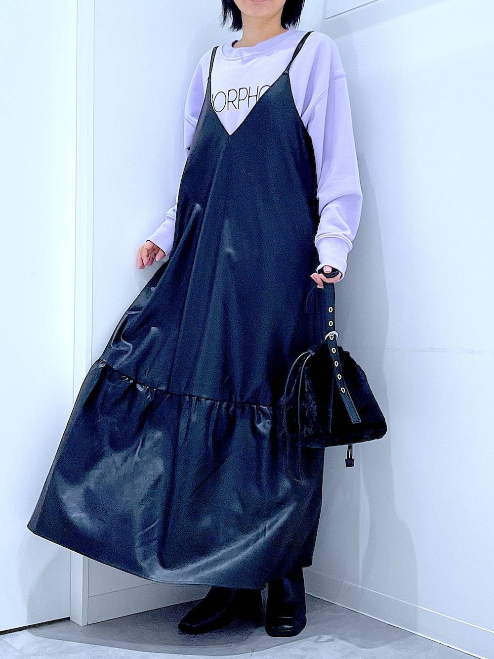 ブラック系のハンドバッグ、ブラック系のブーツ、パープル系のスウェットを着用したレディースの冬コーディネートの6枚目の写真