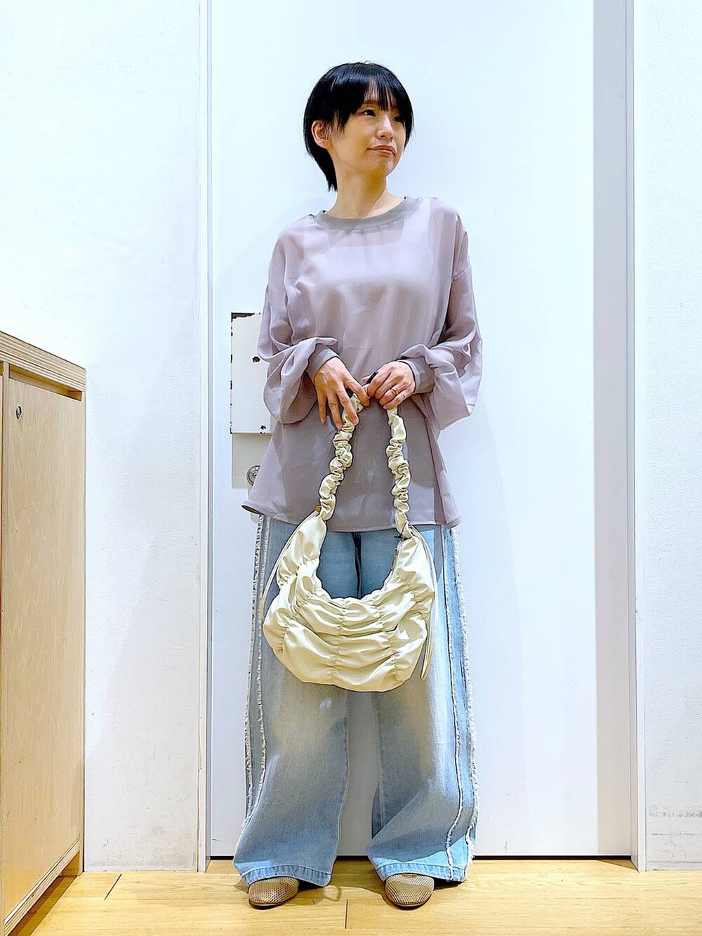 ベージュ系のパンプス、ブルー系のデニムパンツ、グレー系のシャツ/ブラウスを着用したレディースの夏コーディネートの2枚目の写真