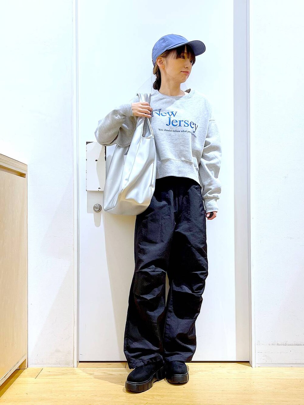 シルバー系のトートバッグ、ブラック系のブーツ、ブラック系のその他パンツを着用したレディースの冬コーディネートの2枚目の写真