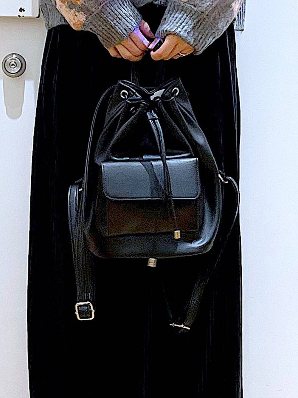 ブラック系のバックパック/リュック、ブラック系のスカート、ブラック系のブーツを着用したレディースの秋コーディネートの9枚目の写真