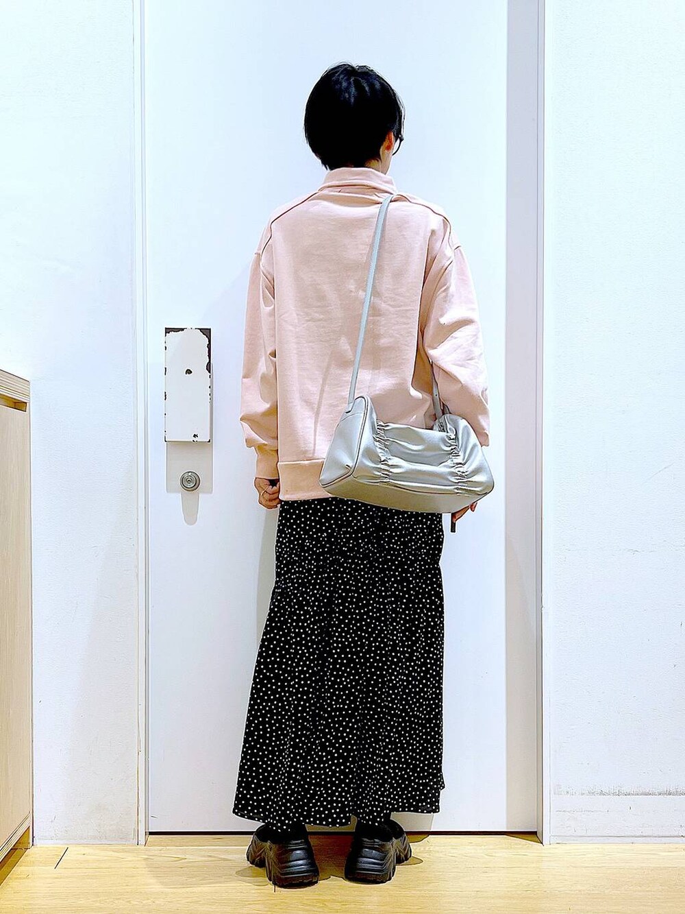 ブラック系のブーツ、シルバー系のショルダーバッグ、その他のスカートを着用したレディースの冬コーディネートの5枚目の写真