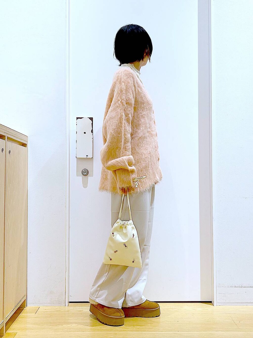 ピンク系のカーディガン/ボレロ、ホワイト系のショルダーバッグ、ホワイト系のTシャツ/カットソーを着用したレディースの冬コーディネートの4枚目の写真