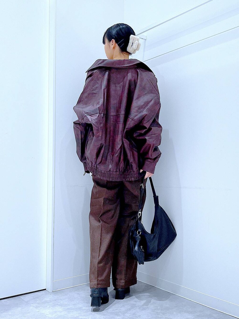 レッド系のブルゾン、ホワイト系のニット/セーター、ブラック系のブーツを着用したレディースの秋コーディネートの5枚目の写真