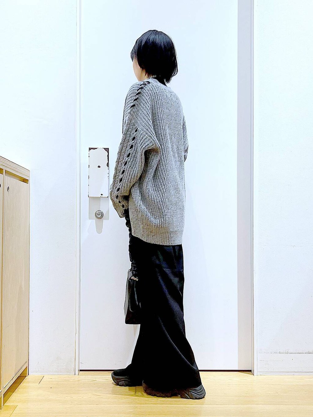 ブラック系のニット/セーター、ブラック系のブーツ、ブラック系のショルダーバッグを着用したレディースの冬コーディネートの3枚目の写真