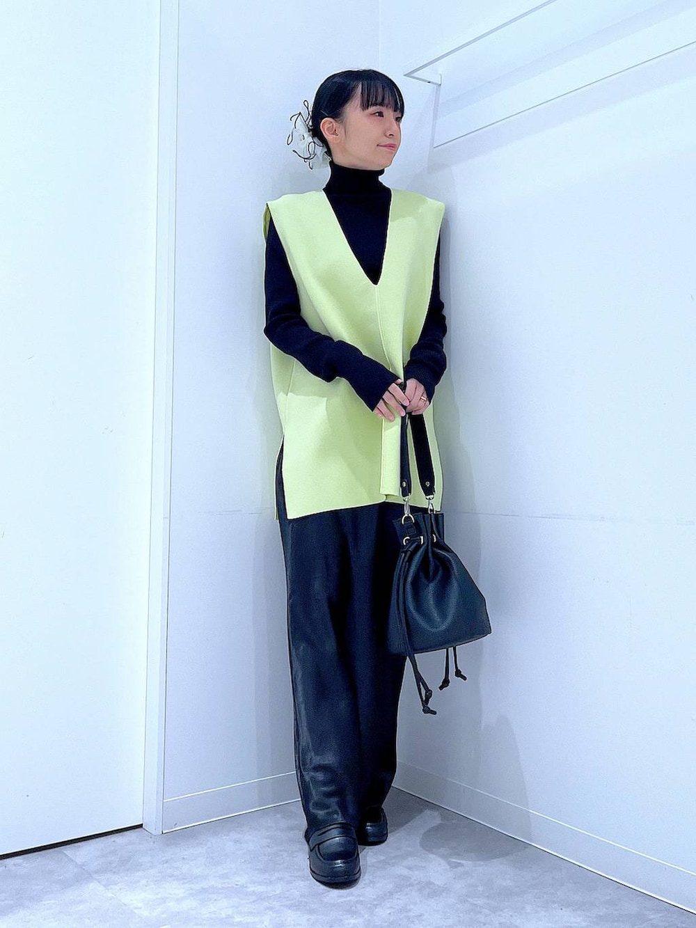 ブラック系のニット/セーター、ブラック系のスカート、ブラック系のローファーを着用したレディースの春コーディネートの2枚目の写真