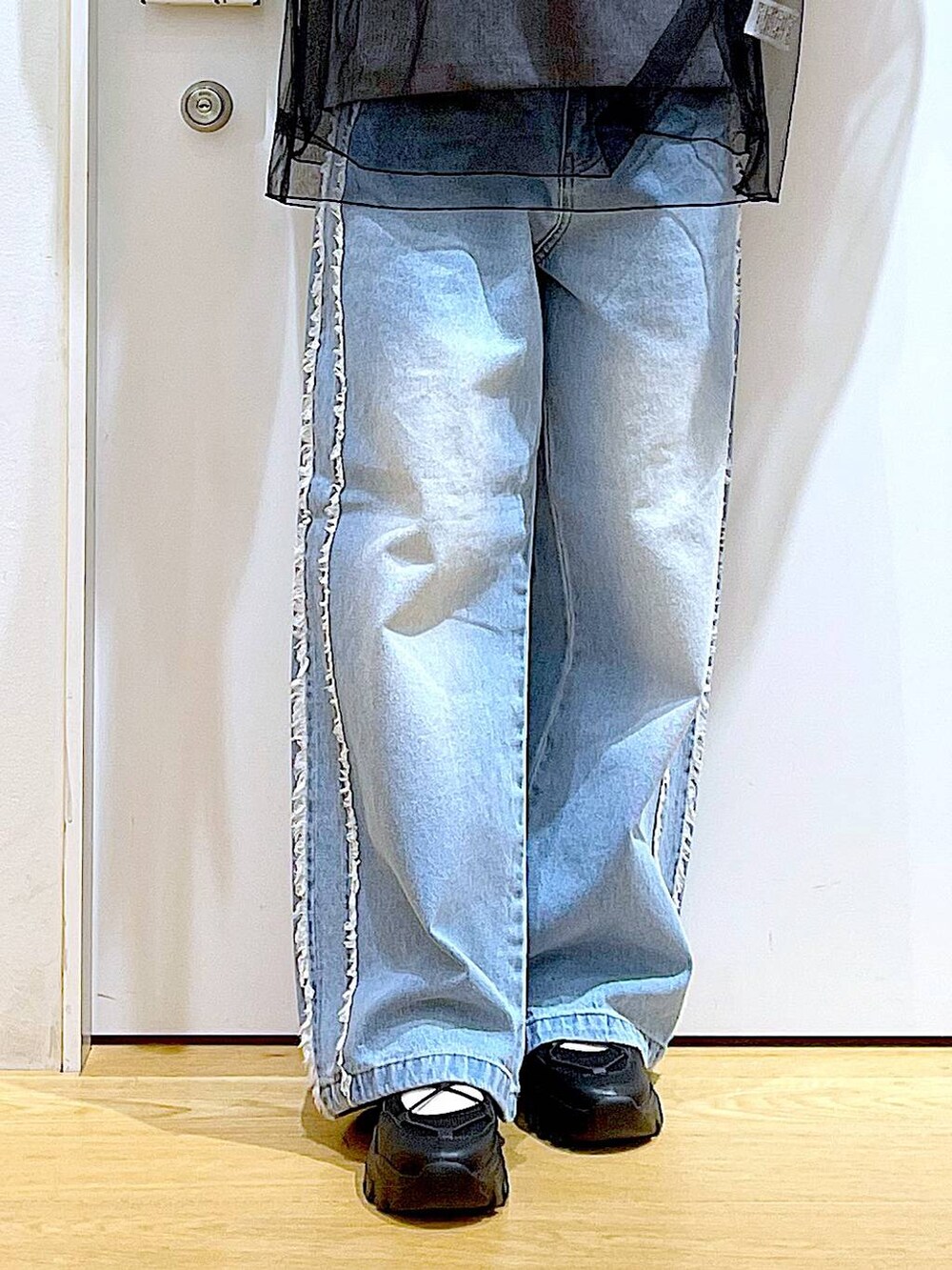 ブラック系のスニーカー、ブラック系のショルダーバッグ、ブルー系のデニムパンツを着用したレディースの春コーディネートの8枚目の写真