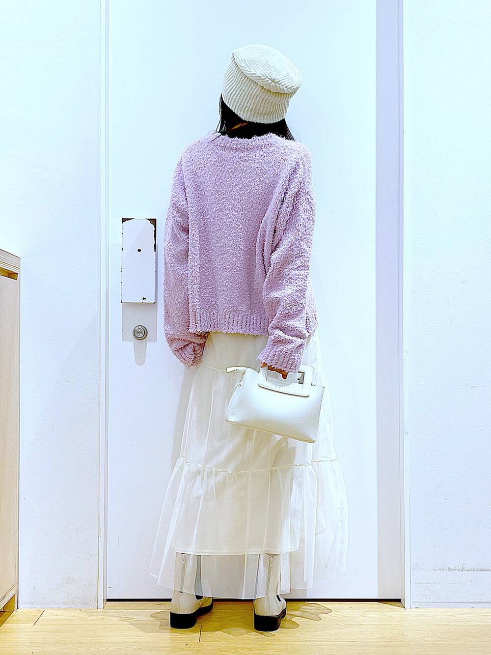 パープル系のニット/セーター、ベージュ系のブーツ、ホワイト系のショルダーバッグを着用したレディースの春コーディネートの5枚目の写真