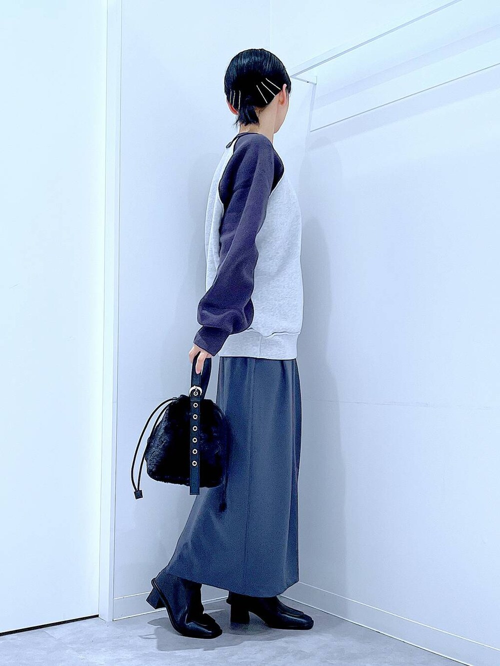 グレー系のスカート、グレー系のニット/セーター、ブラック系のブーツを着用したレディースの秋コーディネートの4枚目の写真