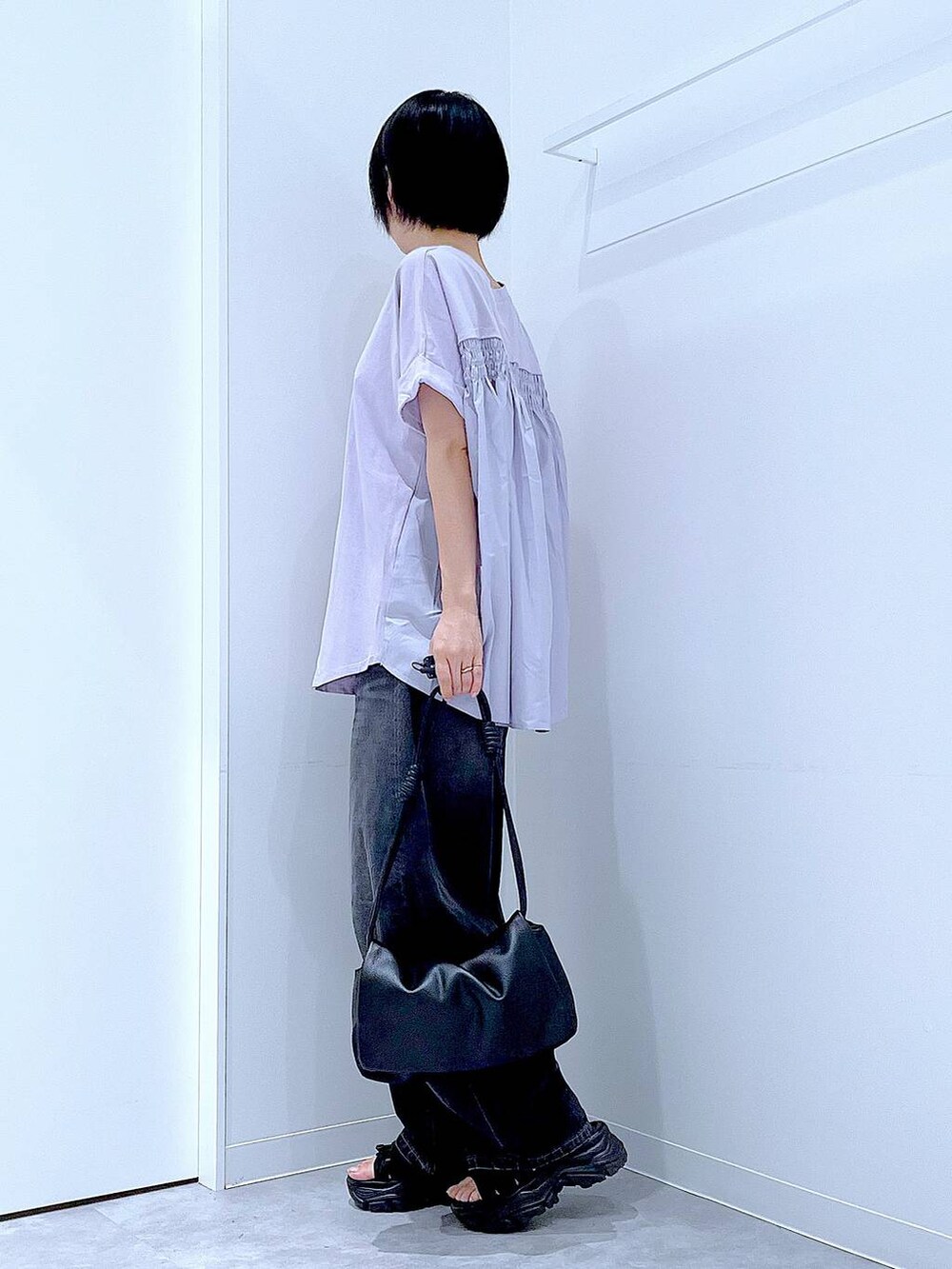 ブラック系のデニムパンツ、ブラック系のスニーカー、パープル系のTシャツ/カットソーを着用したレディースの夏コーディネートの3枚目の写真