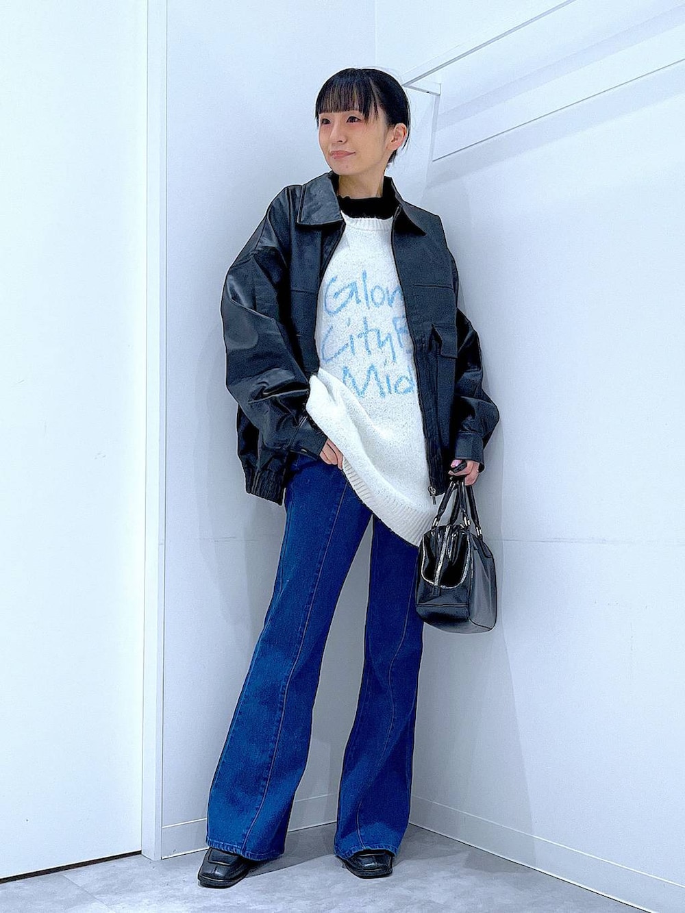 ブラック系のブルゾン、ブラック系のブーツ、ブラック系のショルダーバッグを着用したレディースの冬コーディネートの2枚目の写真