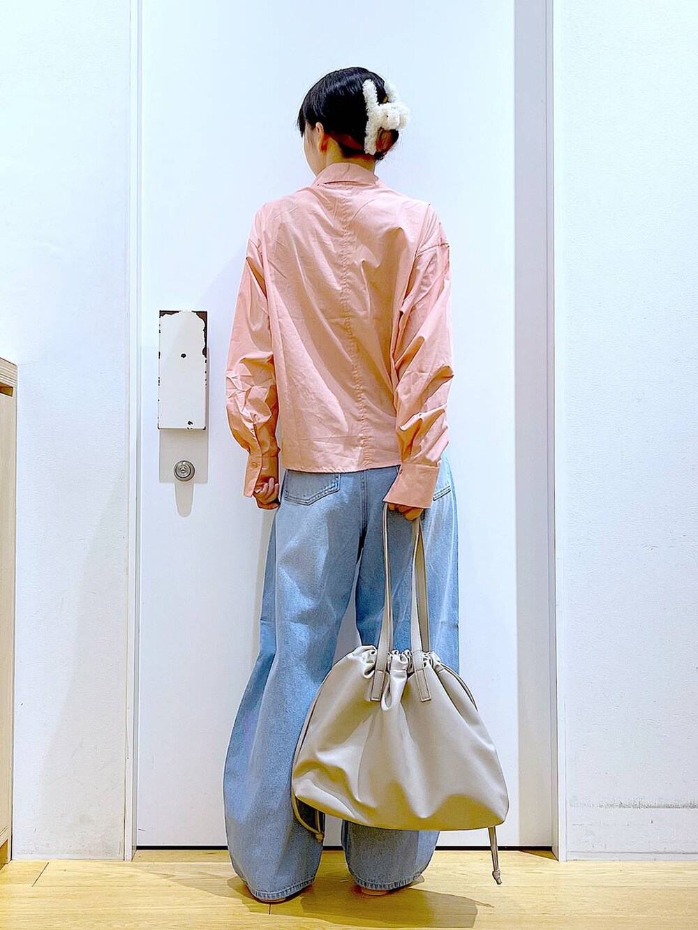 ベージュ系のトートバッグ、ブルー系のデニムパンツ、シルバー系のパンプスを着用したレディースの秋コーディネートの5枚目の写真