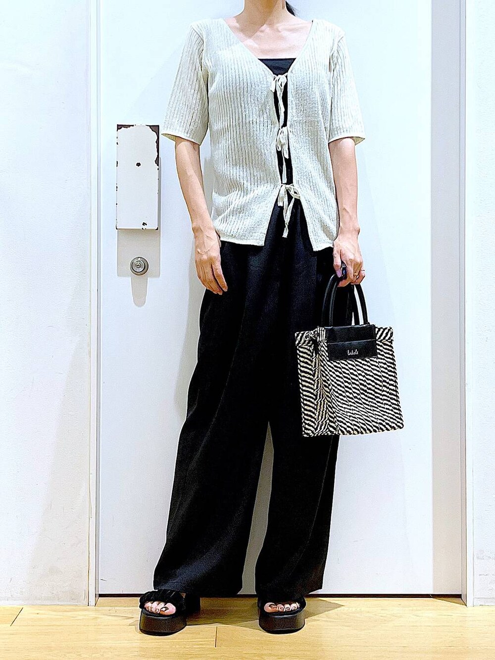 ブラック系のキャミソール、ブラック系のショルダーバッグ、ブラック系のサンダルを着用したレディースの夏コーディネートの6枚目の写真