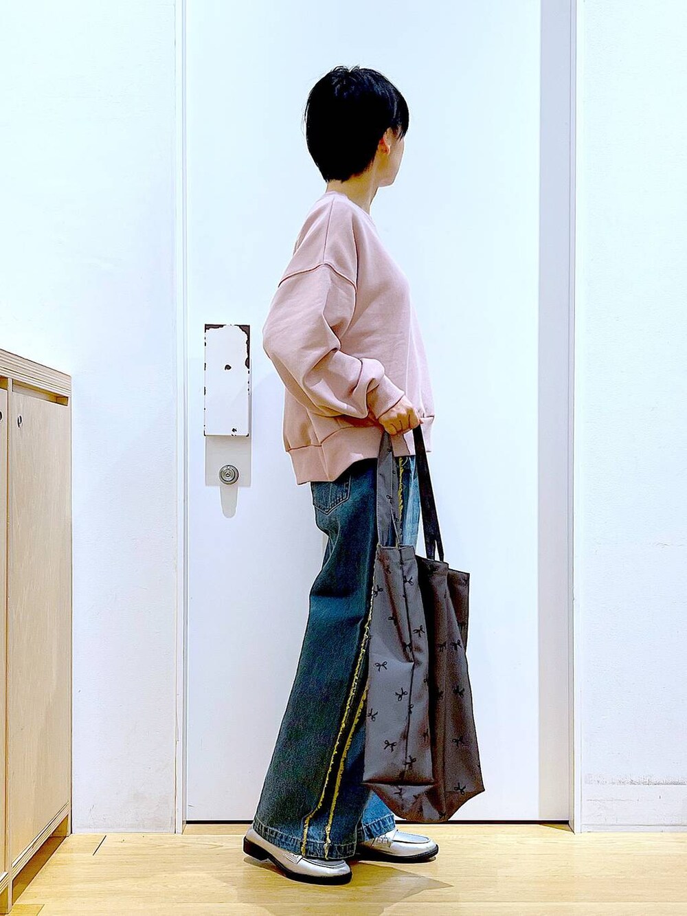 シルバー系のローファー、ブルー系のデニムパンツ、その他のトートバッグを着用したレディースの春コーディネートの4枚目の写真