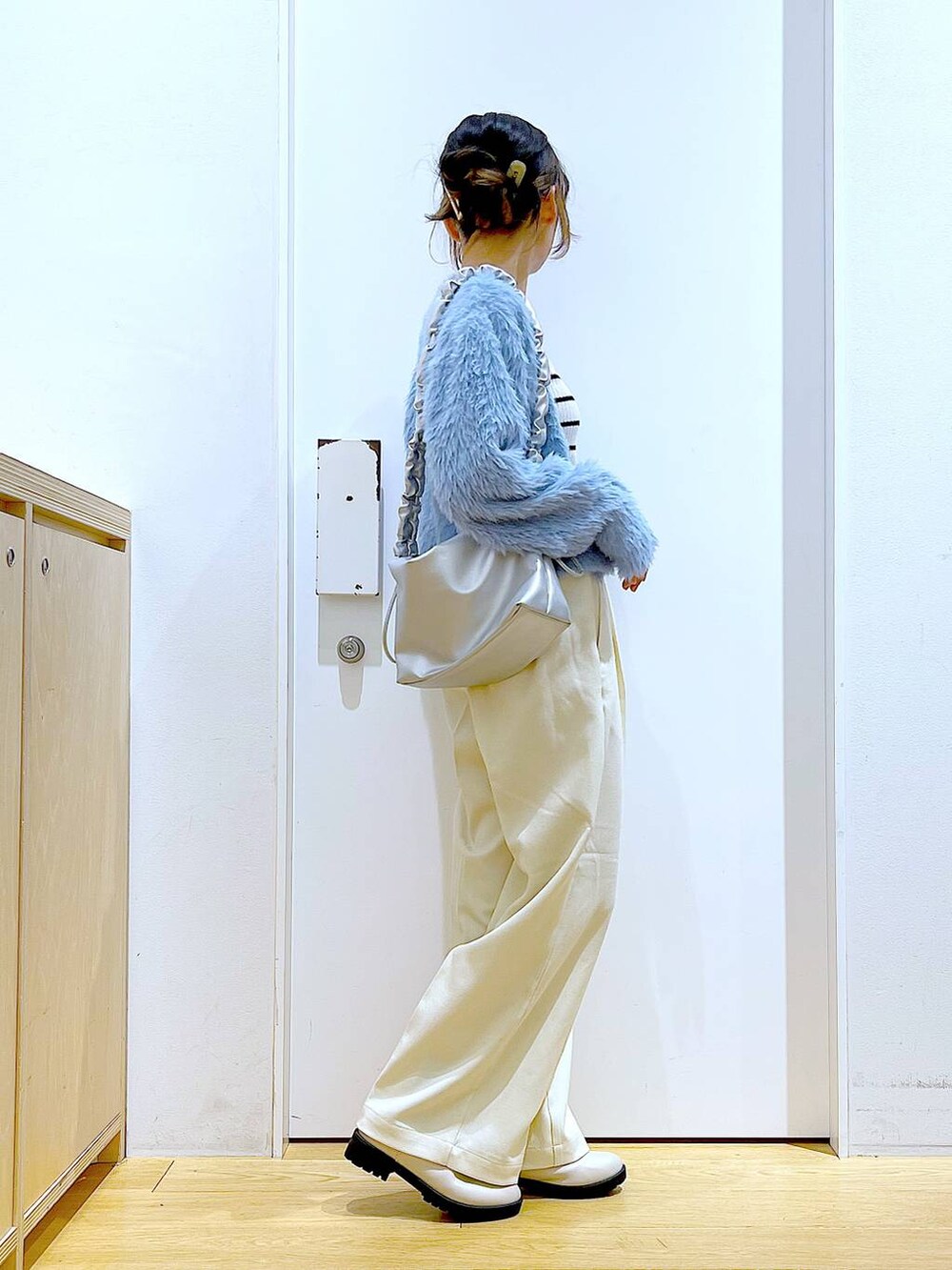 シルバー系のショルダーバッグ、ベージュ系のブーツ、ホワイト系のニット/セーターを着用したレディースの冬コーディネートの4枚目の写真