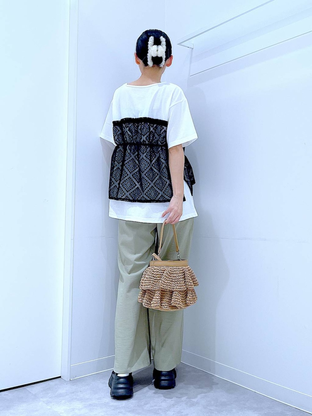 ベージュ系のショルダーバッグ、ブラック系のスニーカー、ホワイト系のTシャツ/カットソーを着用したレディースの春コーディネートの5枚目の写真