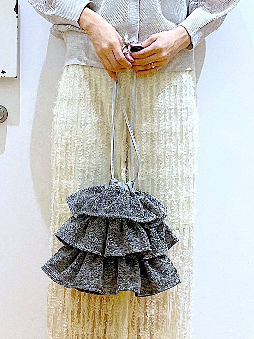 シルバー系のショルダーバッグ、ホワイト系のニット/セーター、ホワイト系のその他パンツを着用したレディースの夏コーディネートの9枚目の写真