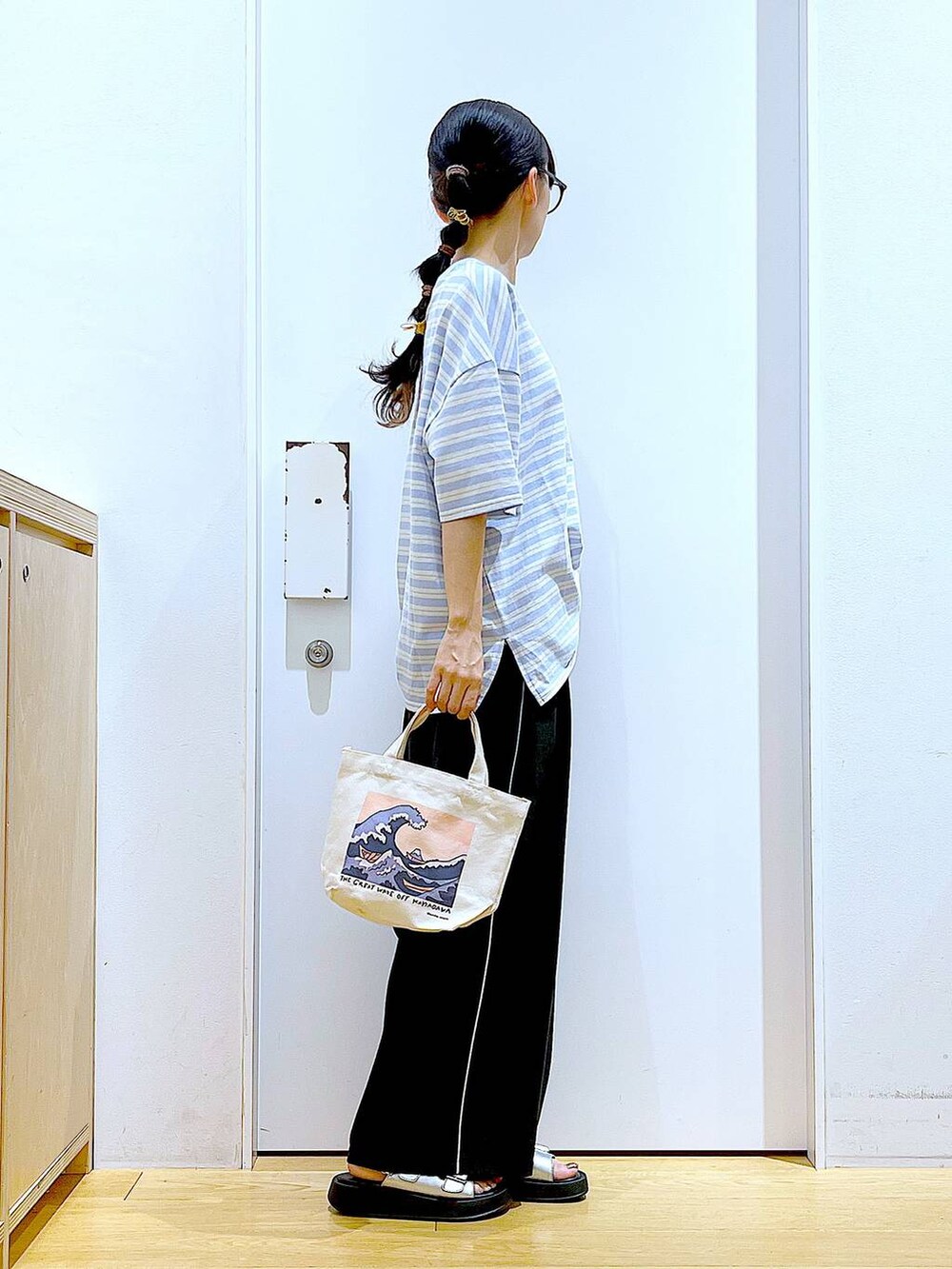 シルバー系のサンダル、その他のトートバッグ、ブルー系のTシャツ/カットソーを着用したレディースの夏コーディネートの4枚目の写真