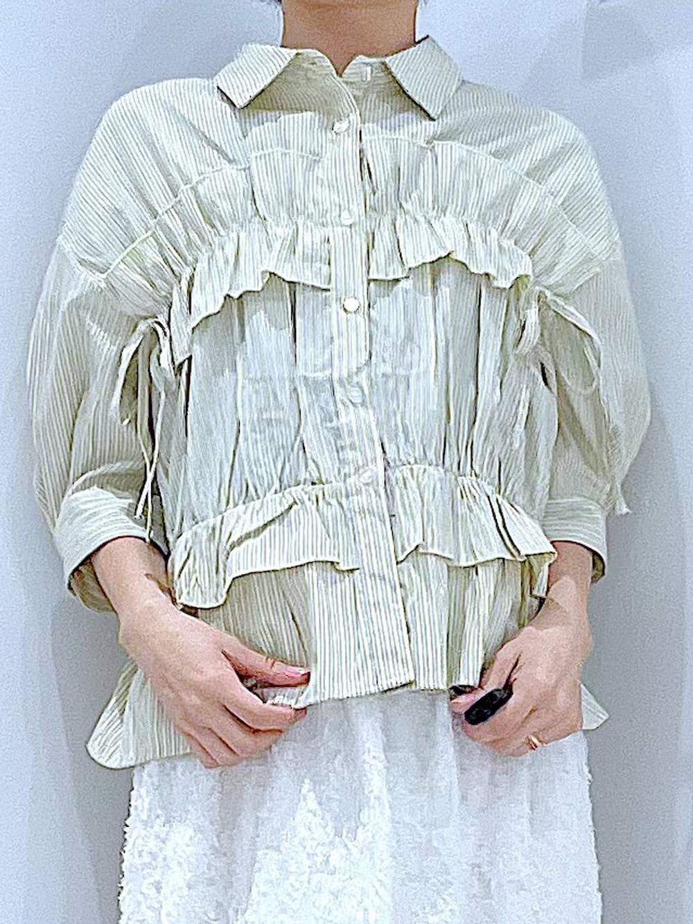 ベージュ系のショルダーバッグ、ホワイト系のサンダル、ホワイト系のスカートを着用したレディースの夏コーディネートの7枚目の写真