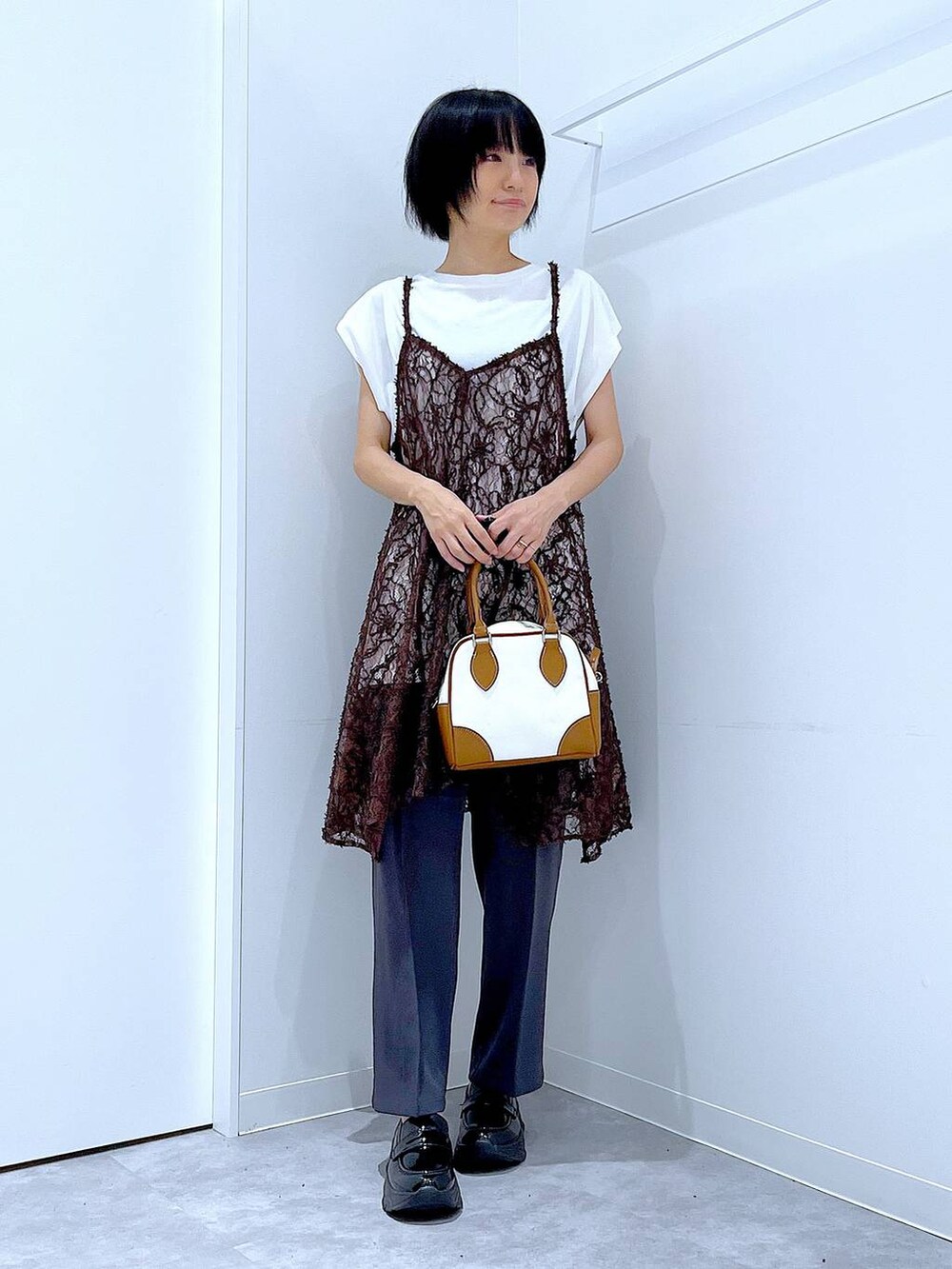 ホワイト系のTシャツ/カットソー、ブラック系のローファー、ベージュ系のチュニックを着用したレディースの夏コーディネートの2枚目の写真