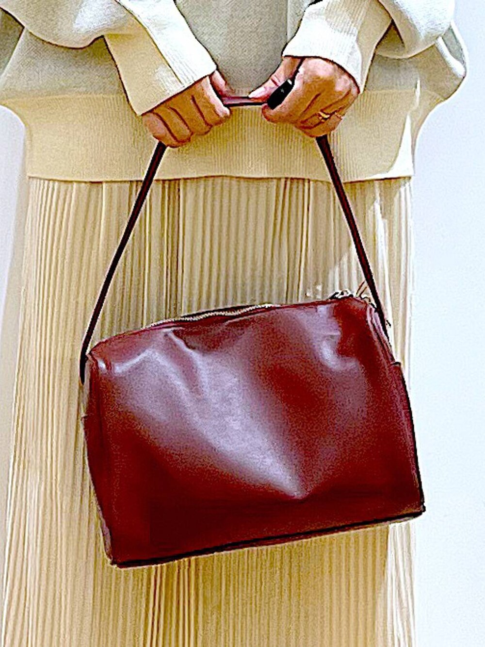 ベージュ系のニット/セーター、レッド系のショルダーバッグ、ベージュ系のブーツを着用したレディースの冬コーディネートの9枚目の写真