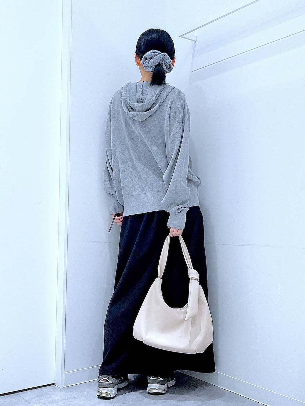 ホワイト系のショルダーバッグ、ブラック系のスカート、グレー系のカーディガン/ボレロを着用したレディースの春コーディネートの5枚目の写真