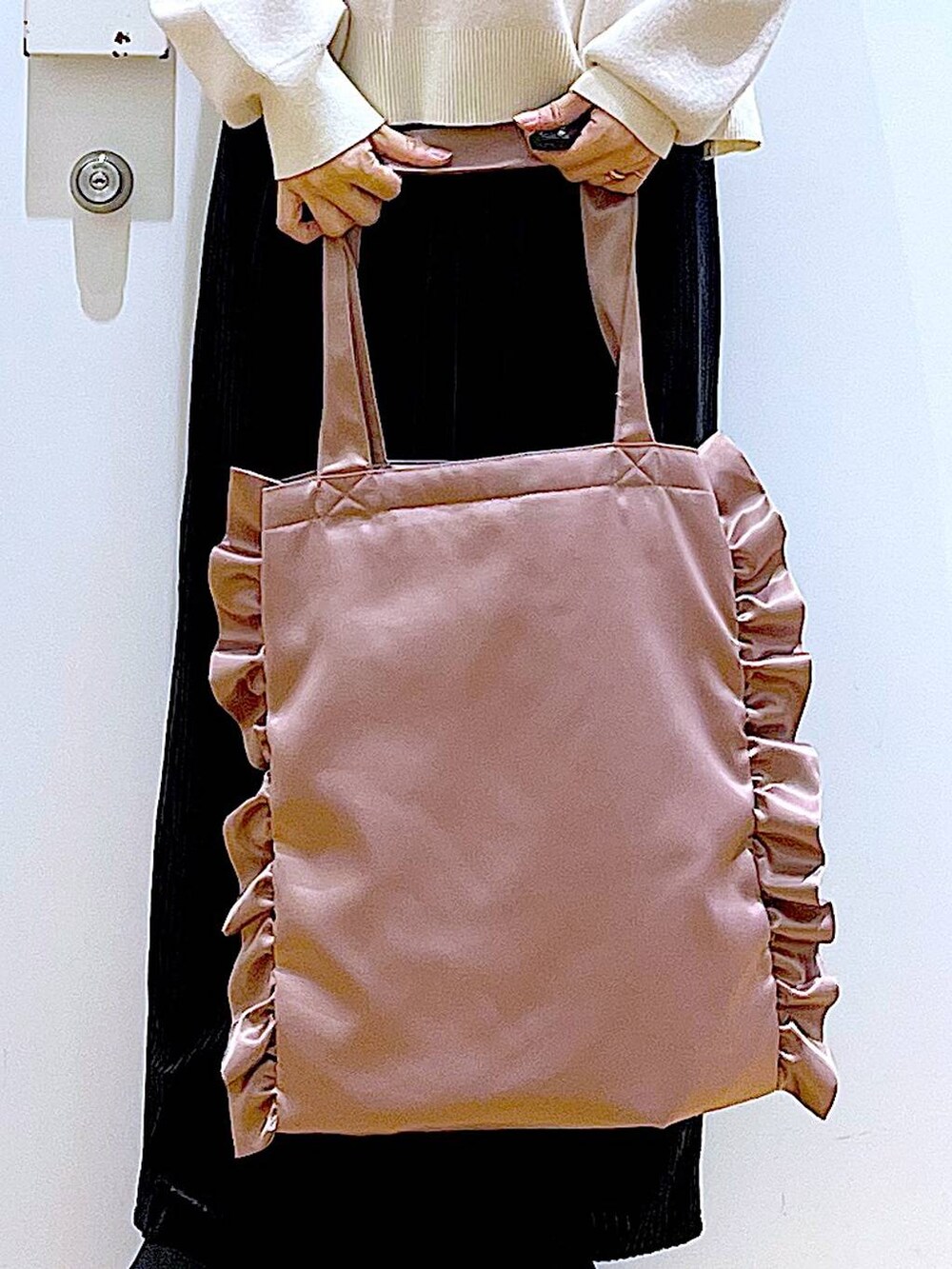 ブラック系のブーツ、ブラック系のスカート、ピンク系のトートバッグを着用したレディースの冬コーディネートの9枚目の写真