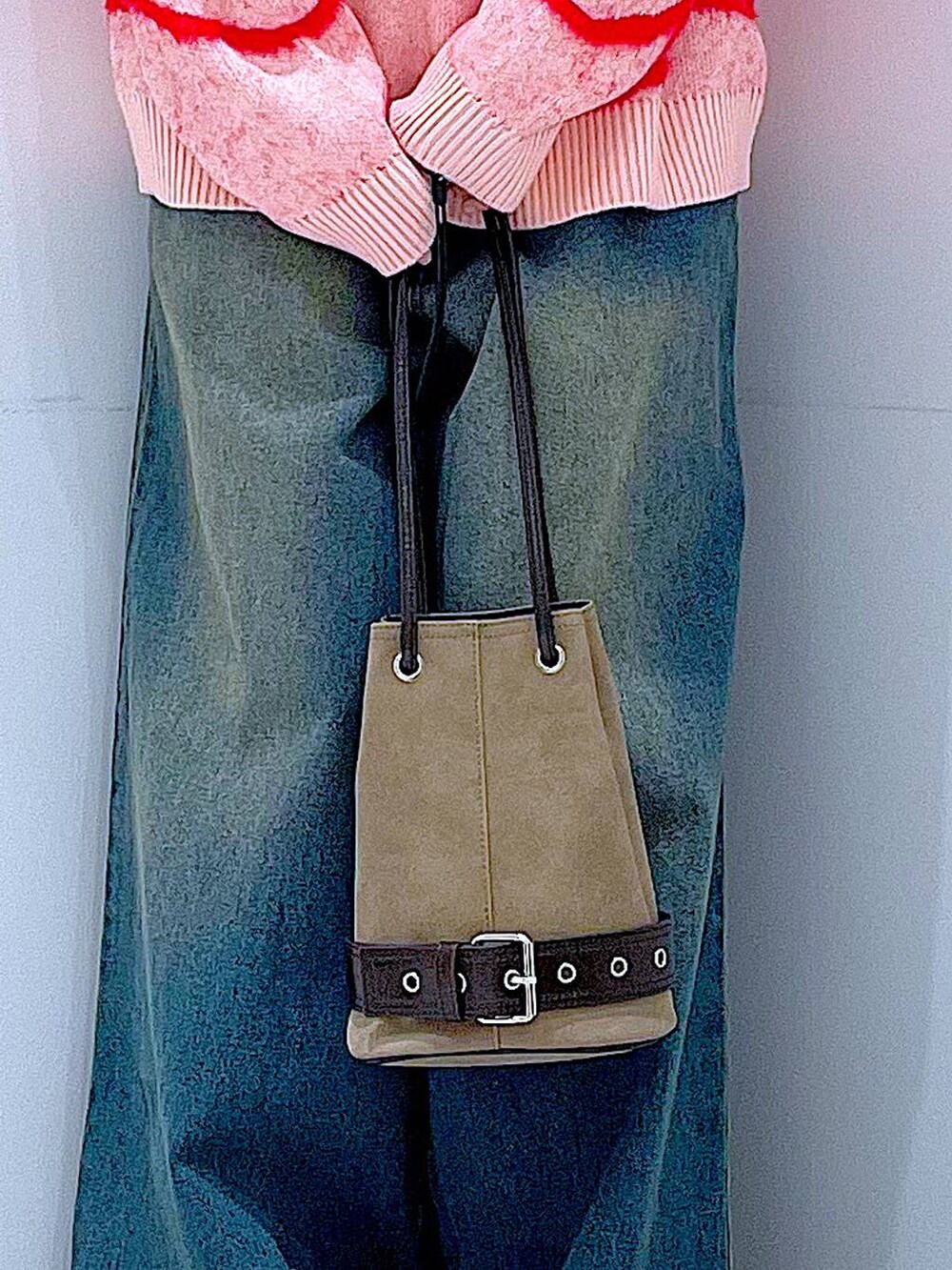 ブルー系のデニムパンツ、ブラック系のブーツ、ベージュ系のハンドバッグを着用したレディースの冬コーディネートの9枚目の写真