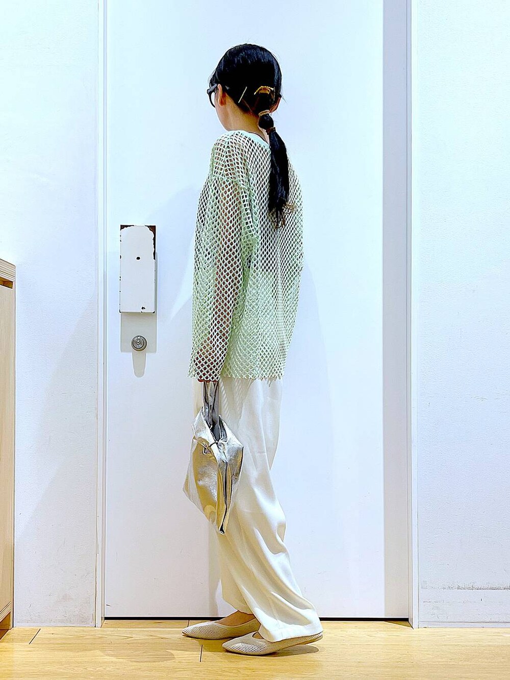 シルバー系のショルダーバッグ、グリーン系のTシャツ/カットソー、ホワイト系のパンプスを着用したレディースの春コーディネートの3枚目の写真