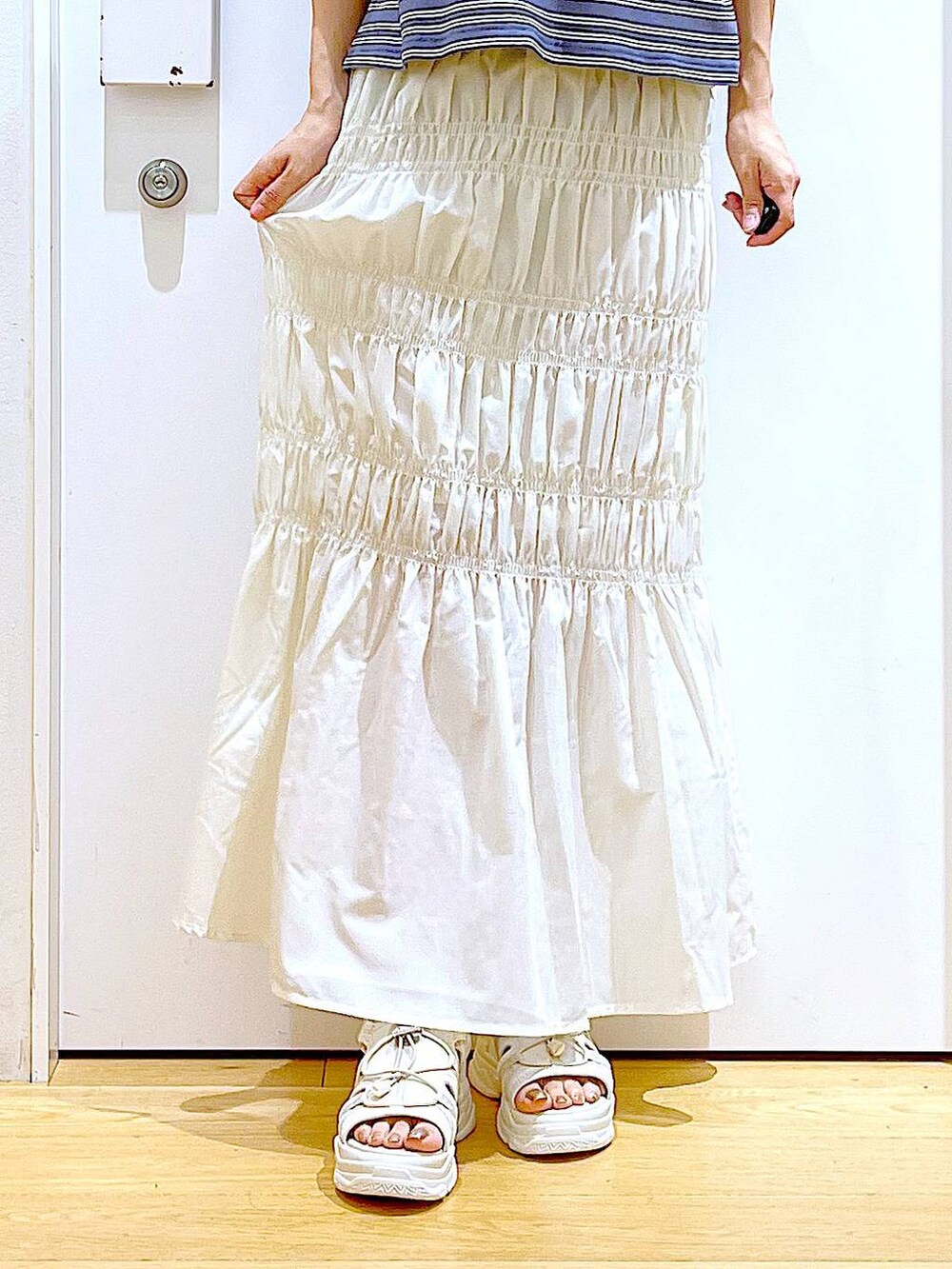 ホワイト系のショルダーバッグ、ホワイト系のサンダル、グレー系のTシャツ/カットソーを着用したレディースの夏コーディネートの8枚目の写真