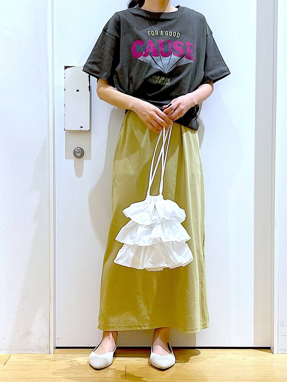 ホワイト系のショルダーバッグ、イエロー系のワンピース、ホワイト系のパンプスを着用したレディースの春コーディネートの6枚目の写真