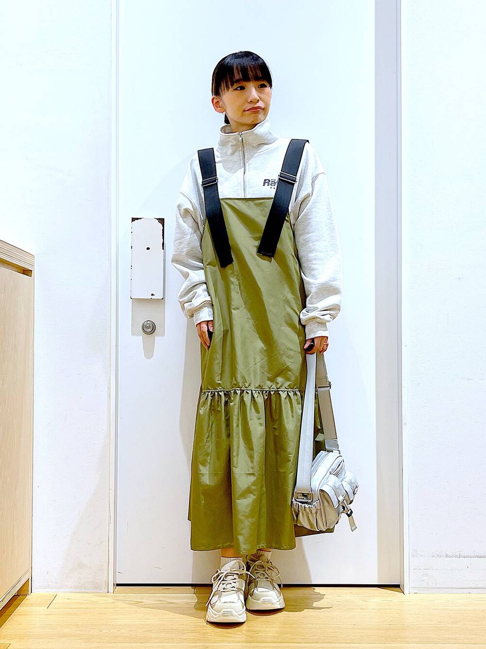 ベージュ系のスウェット、ベージュ系のスニーカー、シルバー系のショルダーバッグを着用したレディースの春コーディネートの2枚目の写真