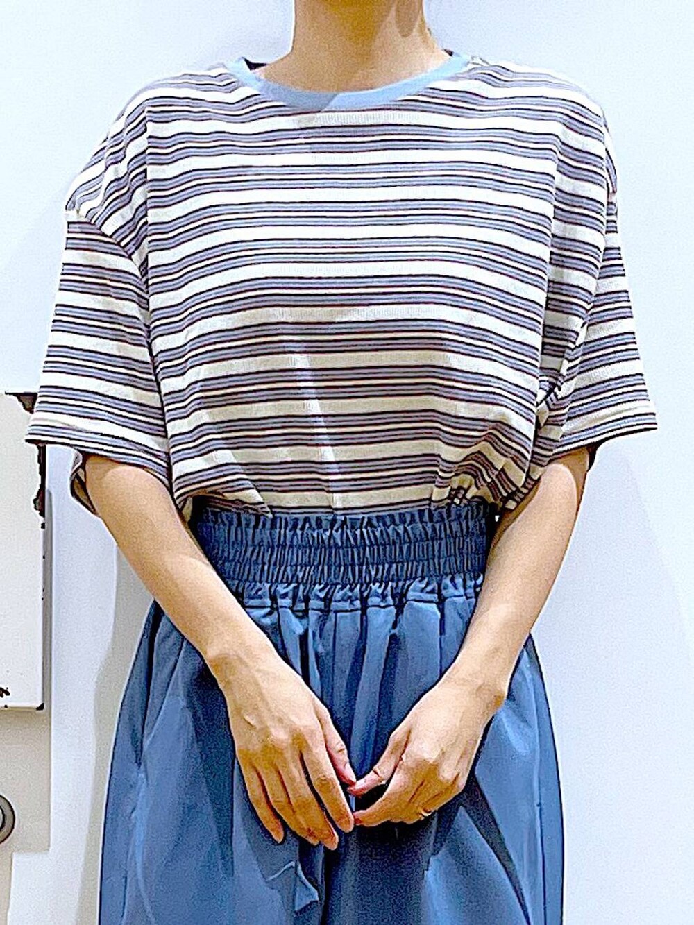 ブラック系のトートバッグ、ブラック系のサンダル、ベージュ系のTシャツ/カットソーを着用したレディースの夏コーディネートの7枚目の写真