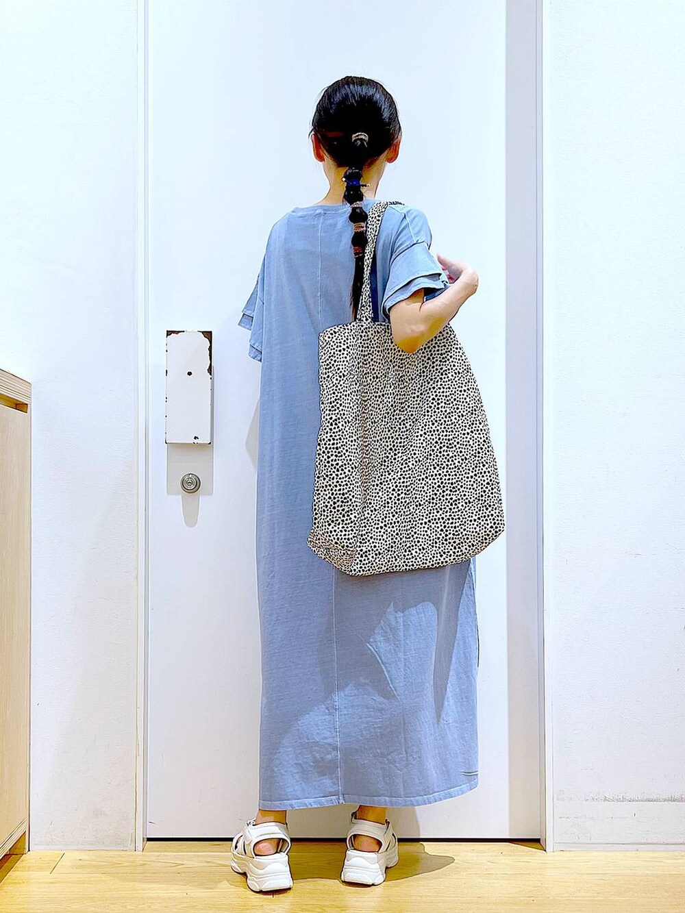 ホワイト系のサンダル、ベージュ系のトートバッグ、ブルー系のワンピースを着用したレディースの夏コーディネートの5枚目の写真