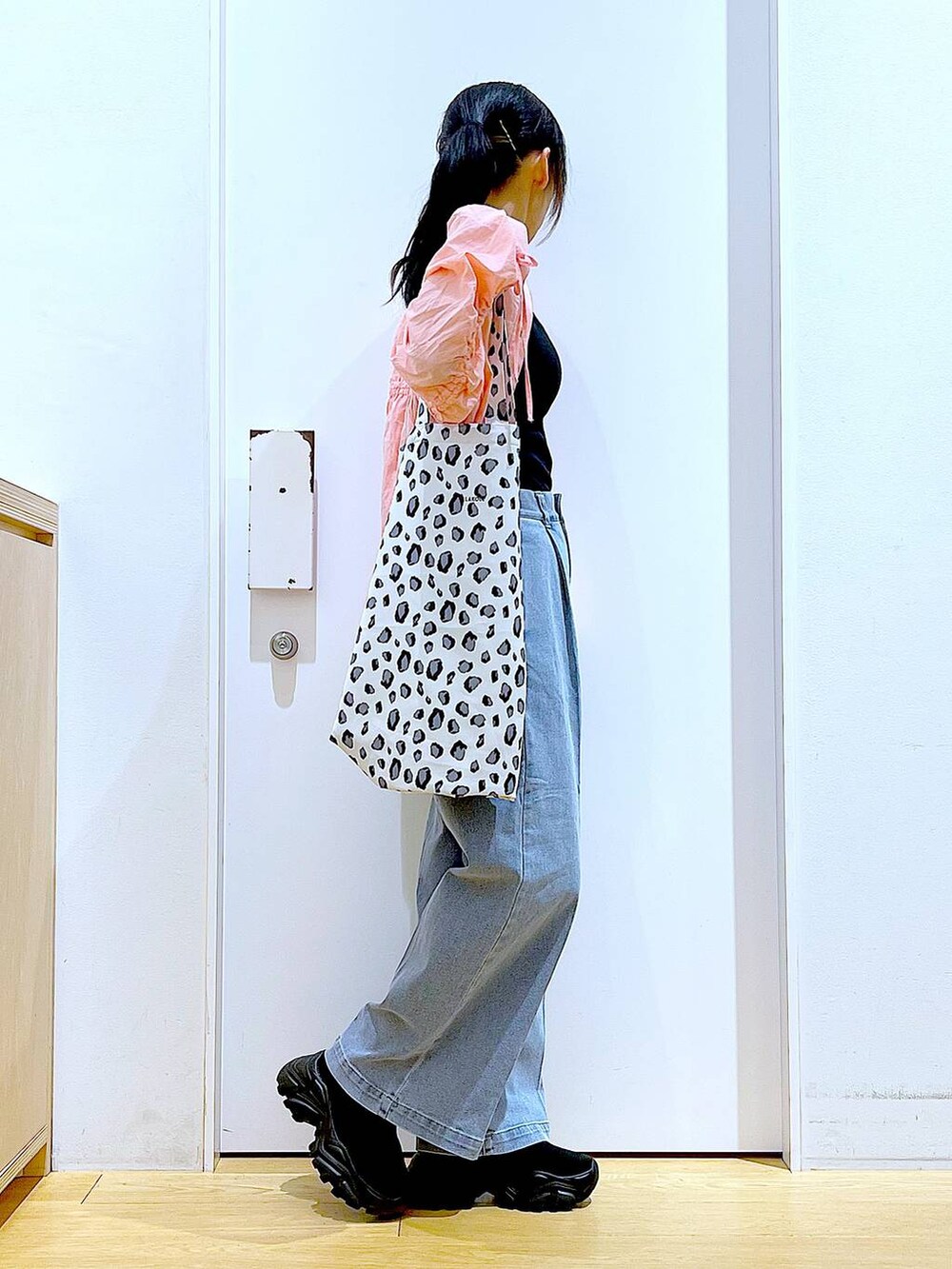 ブルー系のデニムパンツ、ホワイト系のトートバッグ、ピンク系のシャツ/ブラウスを着用したレディースの春コーディネートの4枚目の写真