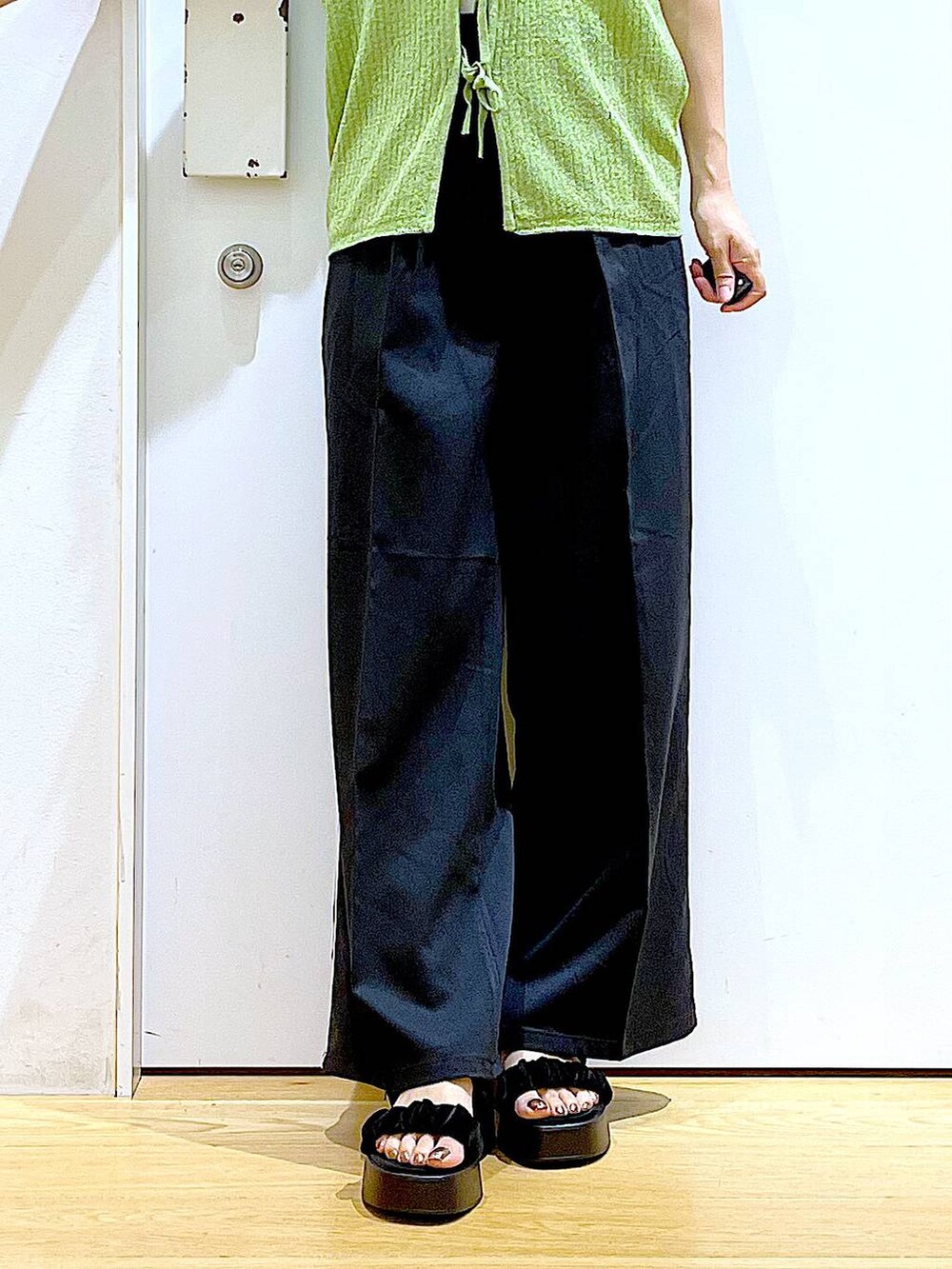 ブラック系のサンダル、ホワイト系のニット/セーター、ブラック系のショルダーバッグを着用したレディースの夏コーディネートの8枚目の写真