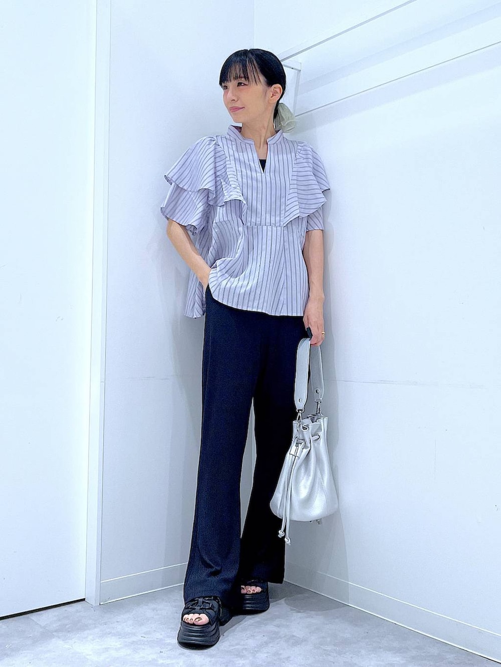 ブラック系のその他パンツ、ブラック系のサンダル、ブルー系のシャツ/ブラウスを着用したレディースの夏コーディネートの2枚目の写真