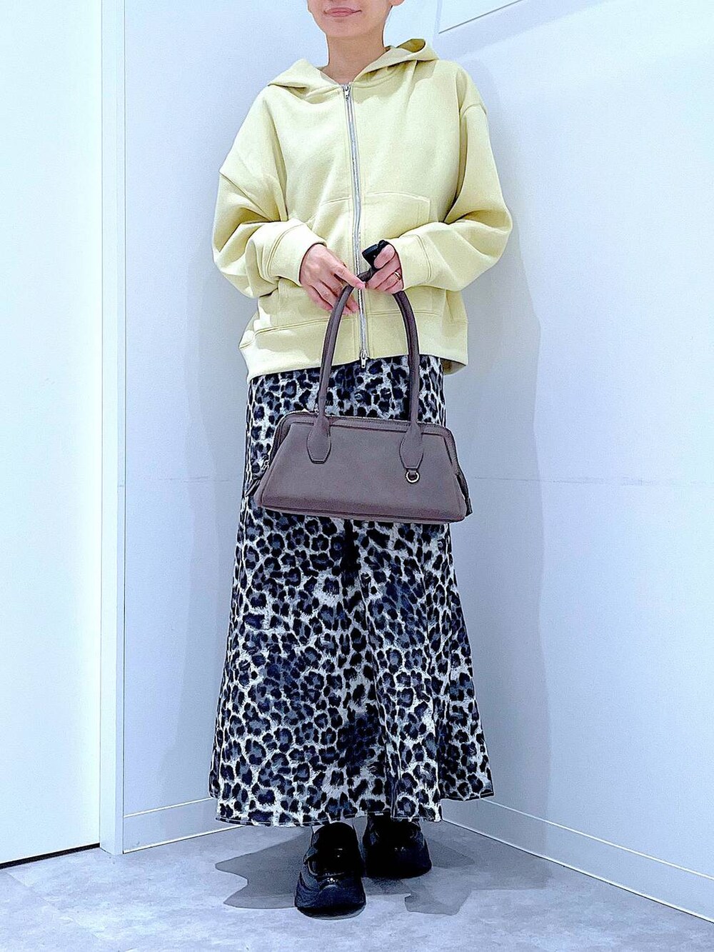 ブラック系のローファー、グレー系のスカート、イエロー系のパーカーを着用したレディースの秋コーディネートの6枚目の写真