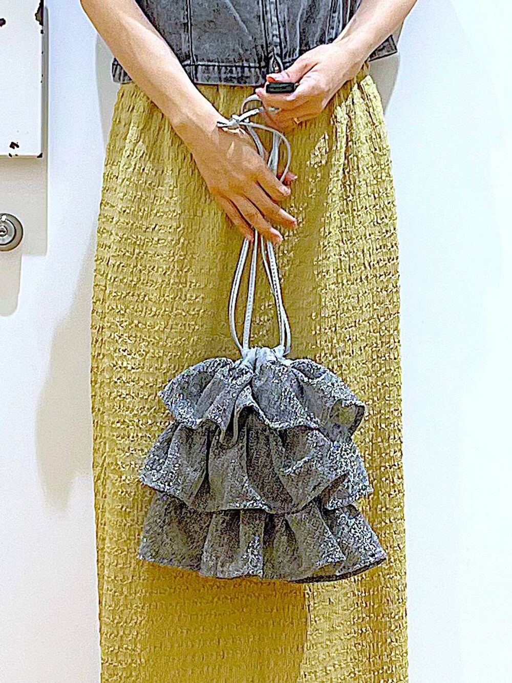 シルバー系のショルダーバッグ、グリーン系のスカート、ブラック系のTシャツ/カットソーを着用したレディースの夏コーディネートの9枚目の写真