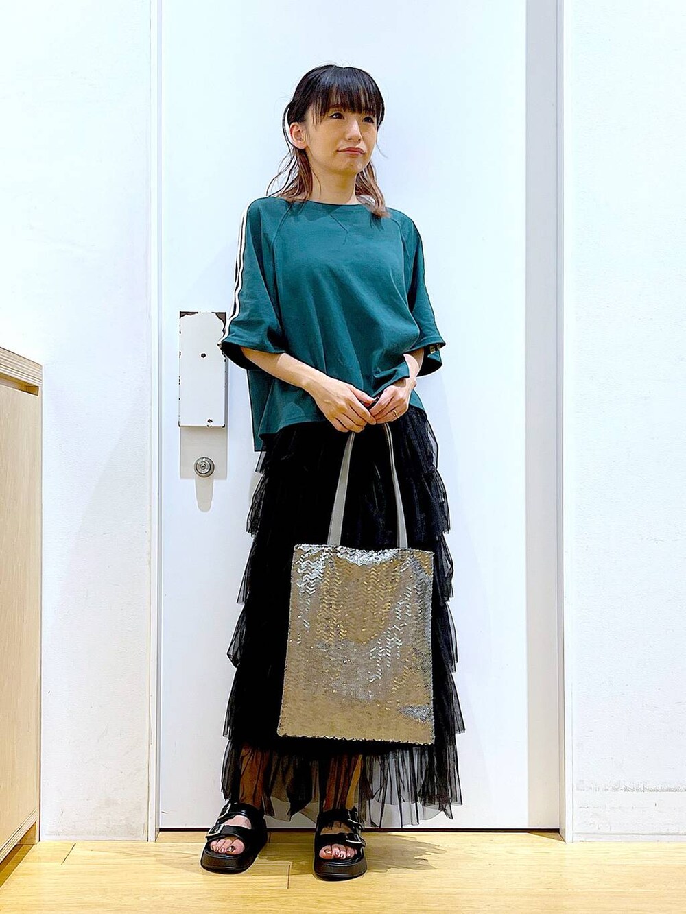 ブラック系のサンダル、シルバー系のトートバッグ、ブラック系のスカートを着用したレディースの夏コーディネートの2枚目の写真