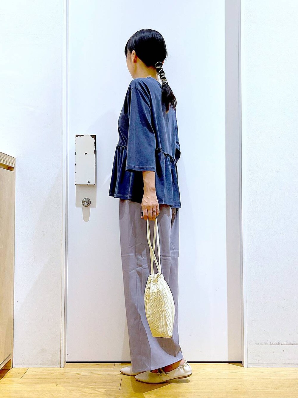 ホワイト系のショルダーバッグ、グレー系のその他パンツ、ホワイト系のパンプスを着用したレディースの秋コーディネートの3枚目の写真