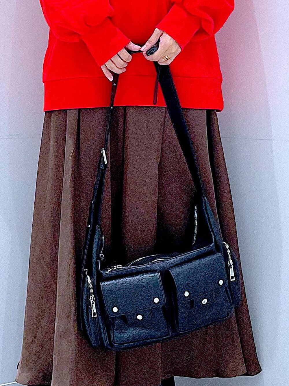 ブラック系のショルダーバッグ、ブラック系のブーツ、レッド系のスウェットを着用したレディースの秋コーディネートの9枚目の写真