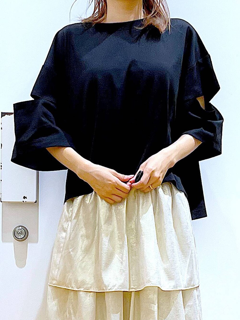 ブラック系のサンダル、ブラック系のショルダーバッグ、ゴールド系のスカートを着用したレディースの夏コーディネートの7枚目の写真