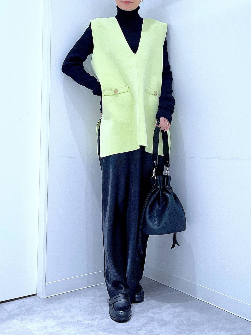 ブラック系のニット/セーター、ブラック系のスカート、ブラック系のローファーを着用したレディースの春コーディネートの6枚目の写真