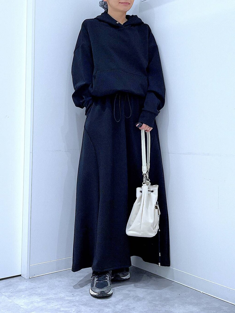 ベージュ系のショルダーバッグ、ブラック系のスウェット、ブラック系のスカートを着用したレディースの春コーディネートの6枚目の写真