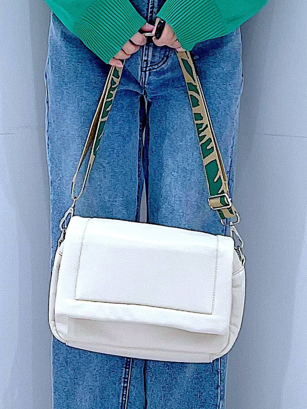 ホワイト系のショルダーバッグ、グリーン系のニット/セーター、ブルー系のデニムパンツを着用したレディースの春コーディネートの9枚目の写真